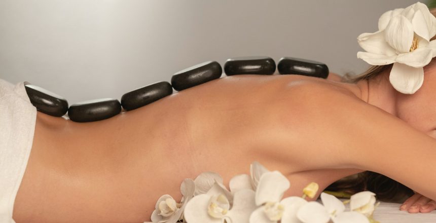 woman on a table with rocks on her back